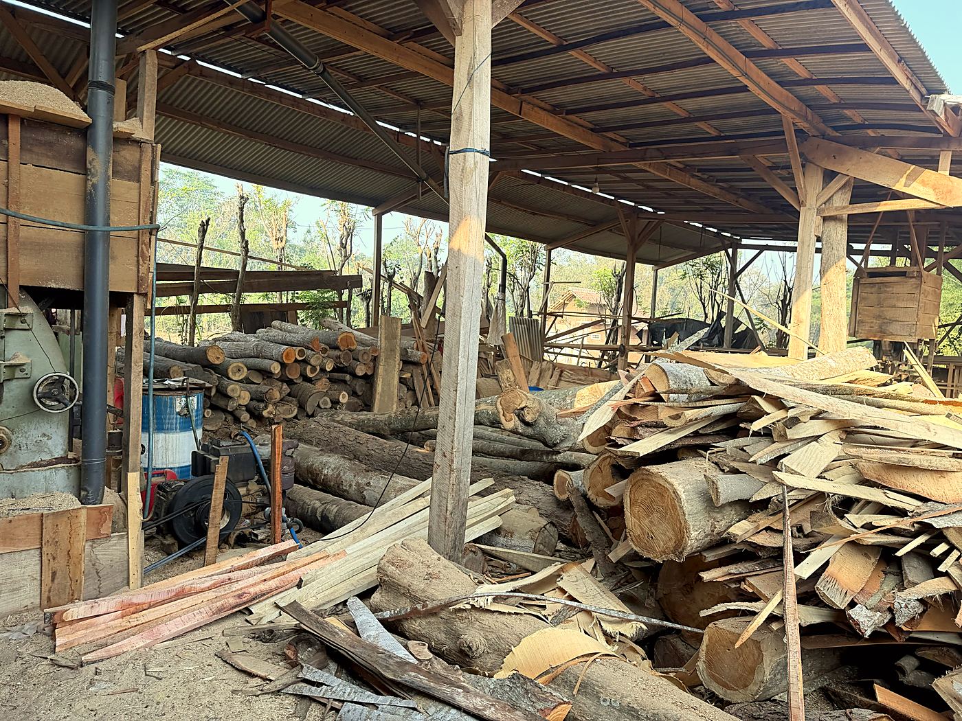 Area kerja gudang dengan tumpukan kayu dan papan